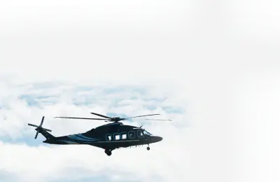 Black helicopter flying against a cloudy sky